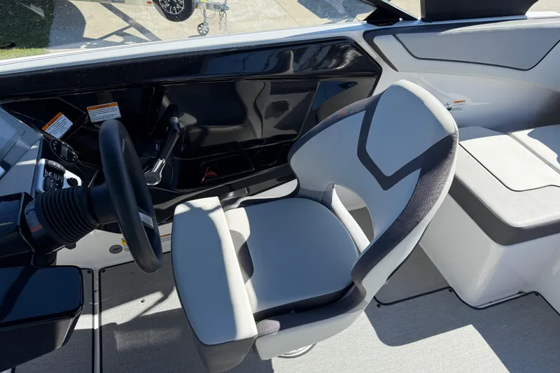 Slide: The Image of 2024 Yamaha Boats AR220 interior with steering wheel and modern seating design. - 32