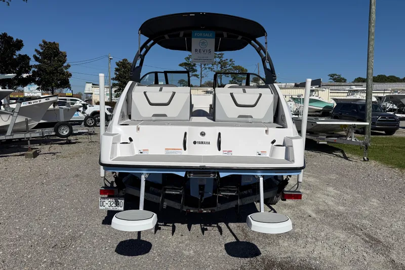 Slide: The Image of 2024 Yamaha Boats AR220, rear view, displayed outdoors, for sale sign visible. - 6