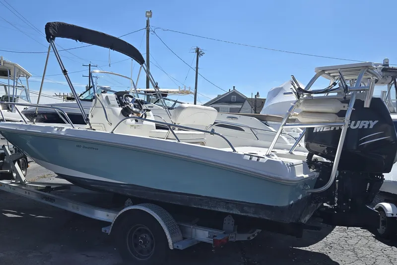 Slide: The Image of 2014 Boston Whaler 180 Dauntless boat with Mercury engine on trailer. - 3