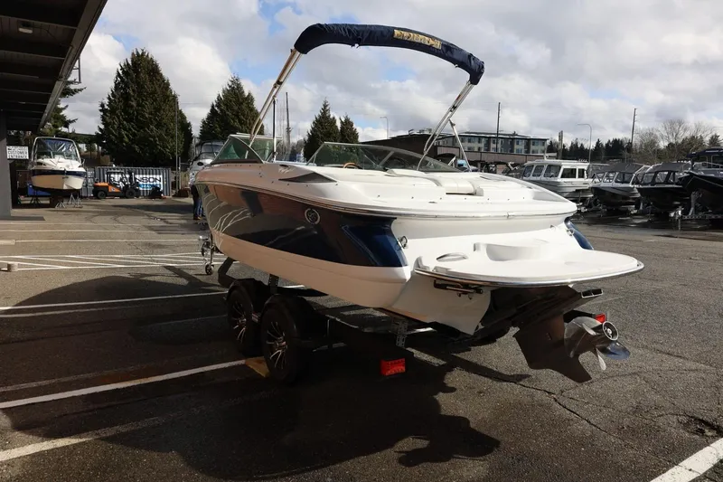 Slide: The Image of 2005 Cobalt 200 boat on trailer in marina parking lot under cloudy sky. - 9