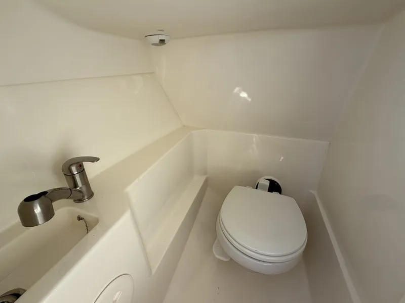 Slide: The Image of Interior of 2023 Boston Whaler 240 Vantage with toilet and sink. - 15