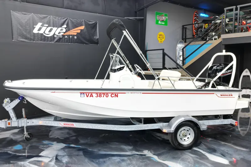 The Image of 2025 Boston Whaler 170 Montauk boat on trailer in showroom setting. - 1