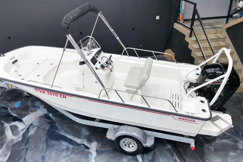 Slide: The Image of 2025 Boston Whaler 170 Montauk boat on trailer, indoor display setting. - 12