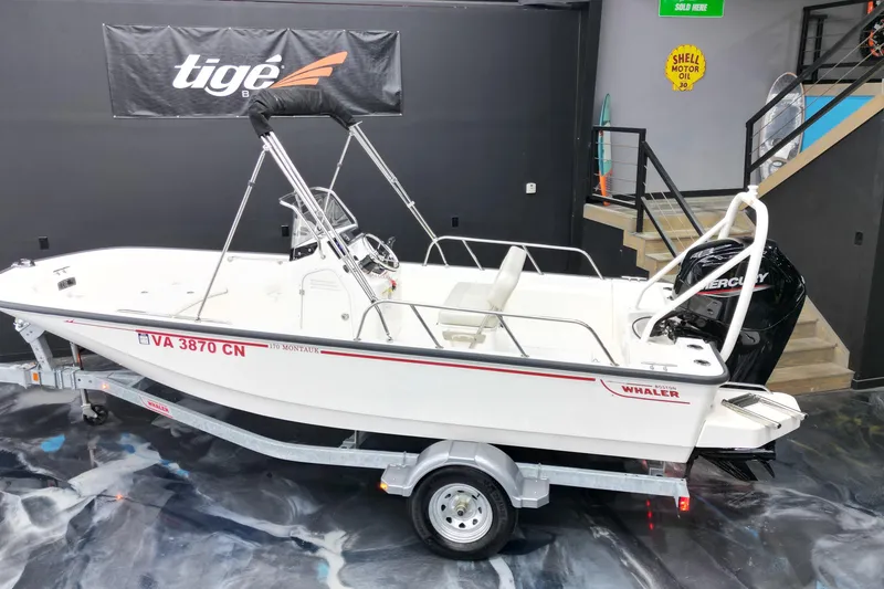 Slide: The Image of 2025 Boston Whaler 170 Montauk boat on trailer in showroom setting. - 14