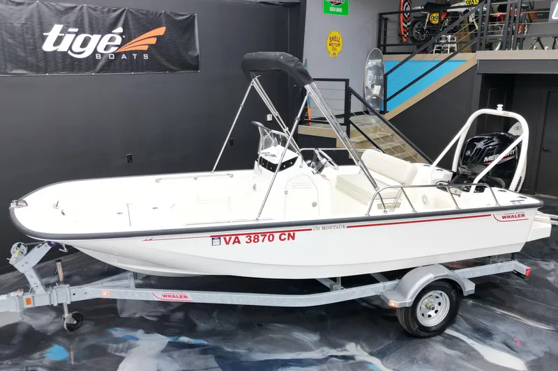 Slide: The Image of 2025 Boston Whaler 170 Montauk boat on trailer in showroom setting. - 15