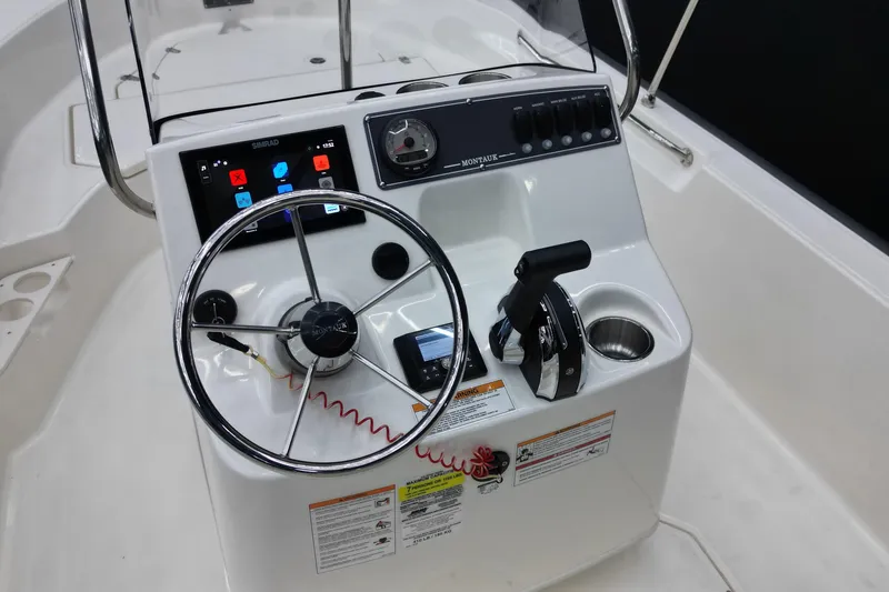 Slide: The Image of 2025 Boston Whaler 170 Montauk boat console with steering wheel and controls. - 7