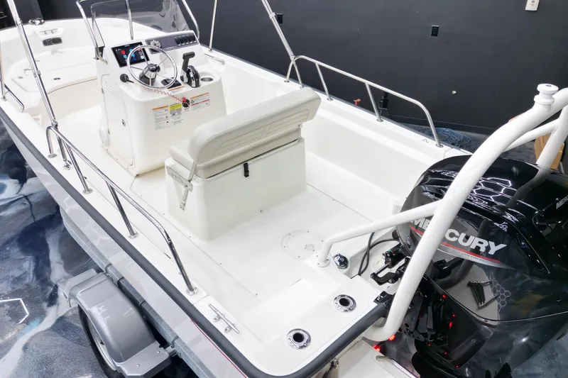 Slide: The Image of 2025 Boston Whaler 170 Montauk boat interior with Mercury engine, featuring steering console and seating. - 9
