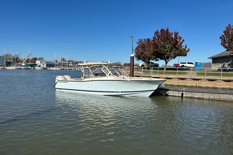 Slide: The Image of 2024 Grady-White Freedom 307 boat docked at a marina under clear blue skies. - 2
