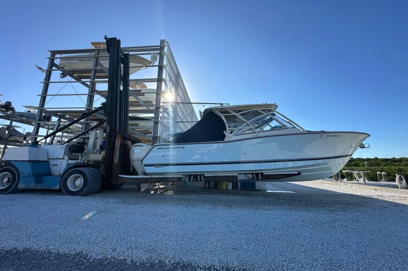 Slide: The Image of 2024 Grady-White Freedom 307 boat on forklift, outdoor storage facility. - 5