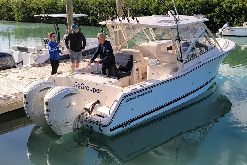 Slide: The Image of 2024 Grady-White Freedom 307 boat docked, featuring dual Yamaha engines and spacious seating. - 8