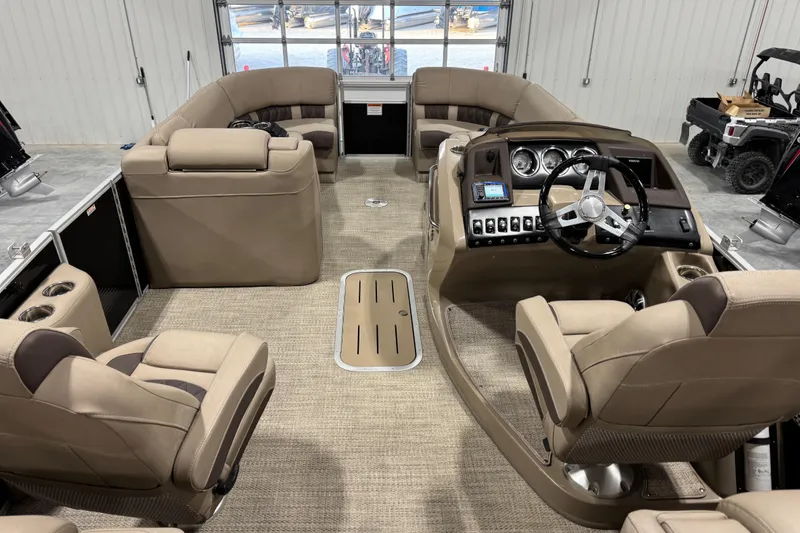 Slide: The Image of Interior of a 2019 Bennington R23 pontoon boat with beige seating and modern dashboard. - 9