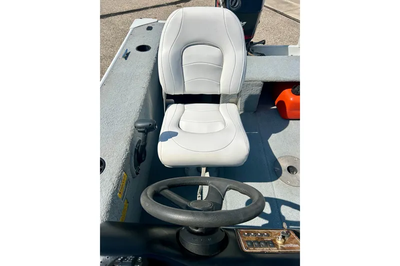 Slide: The Image of 2004 Starcraft D-Star 160 DLX SC boat interior with steering wheel and white captain's chair. - 20