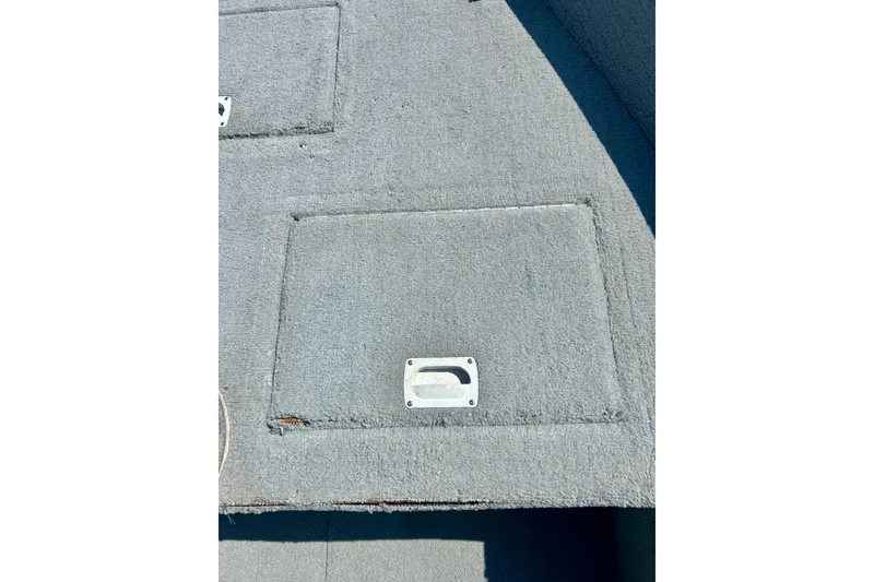 Slide: The Image of 2004 Starcraft D-Star 160 DLX SC boat deck with storage hatch and handle. - 22