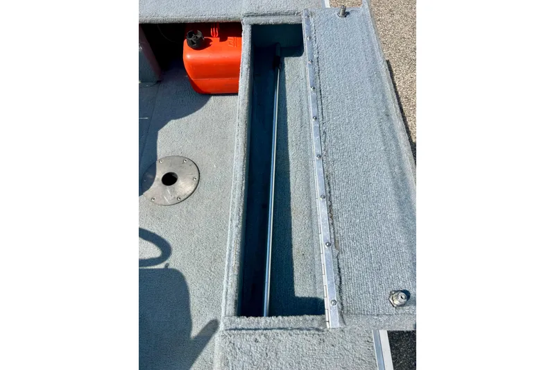 Slide: The Image of Open storage compartment in 2004 Starcraft D-Star 160 DLX SC boat, featuring gray carpet interior. - 30