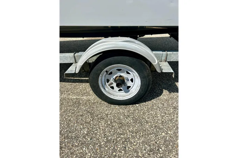 Slide: The Image of 2004 Starcraft D-Star 160 DLX SC trailer wheel on asphalt surface. - 35
