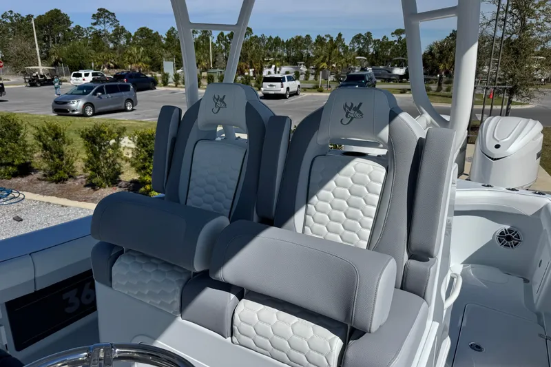 Slide: The Image of 2026 Yellowfin 36 Offshore boat seats with gray and white upholstery in a parking lot setting. - 17