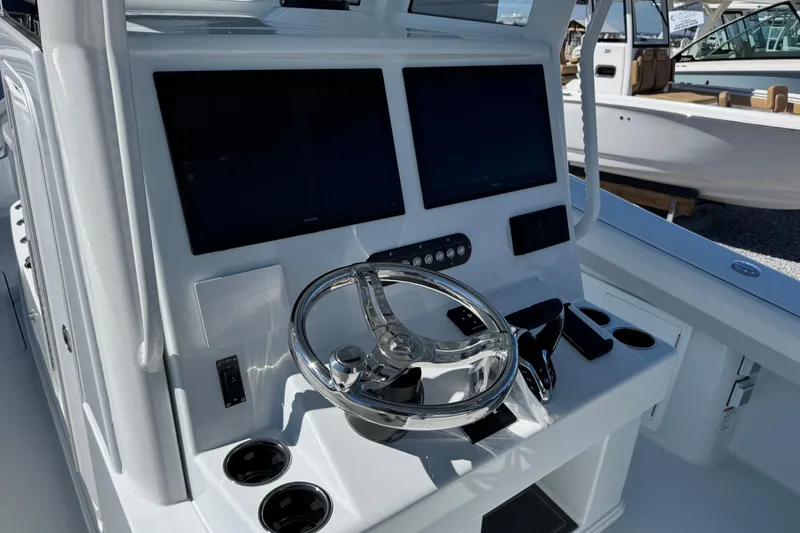 Slide: The Image of 2026 Yellowfin 36 Offshore boat dashboard with dual screens and steering wheel. - 18