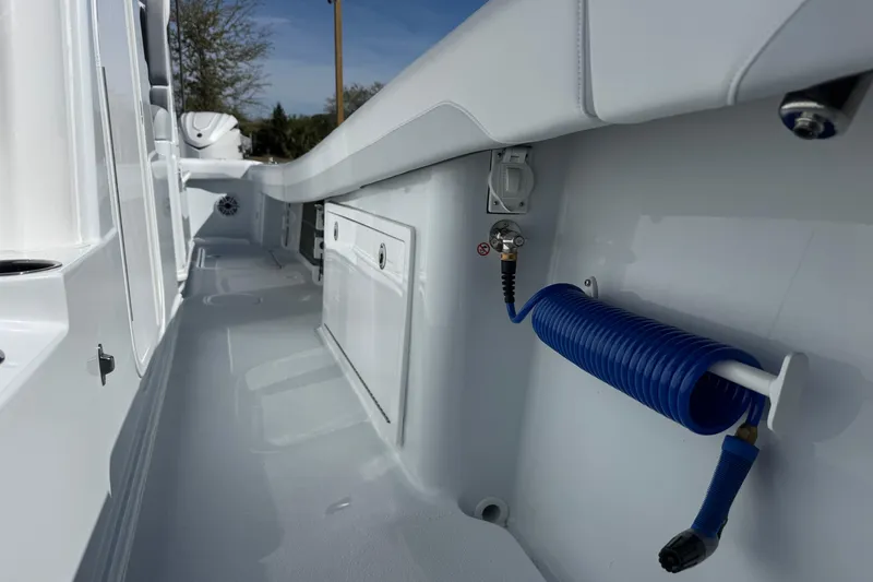 Slide: The Image of 2026 Yellowfin 36 Offshore boat deck with coiled blue hose and storage compartments. - 30