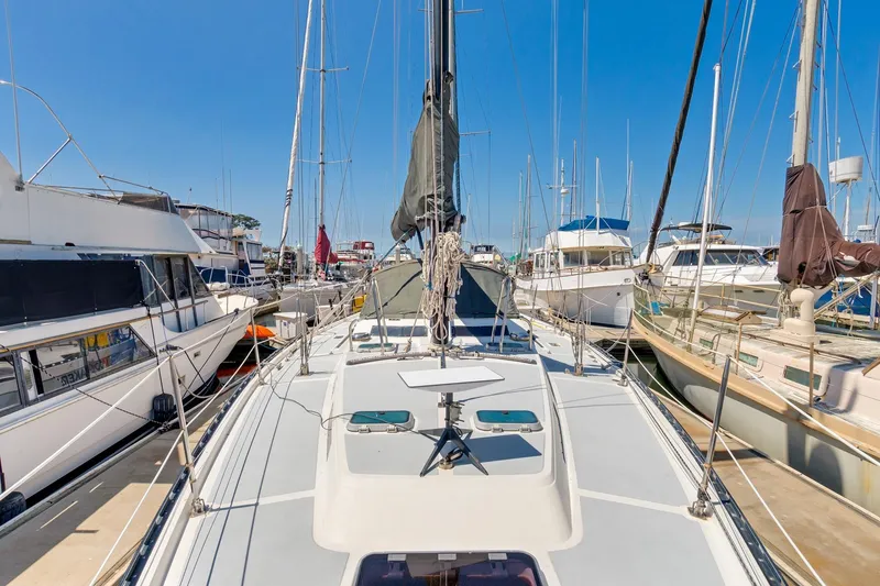 Slide: The Image of 1987 Macintosh Center Cockpit sailboat docked among other boats in a marina. - 2
