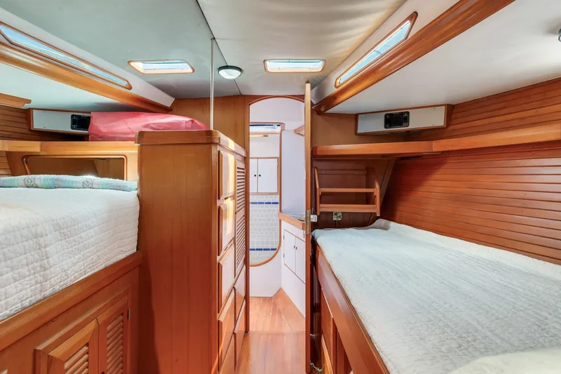 Slide: The Image of Interior of a 1987 Macintosh Center Cockpit yacht with wooden paneling and cozy sleeping quarters. - 24