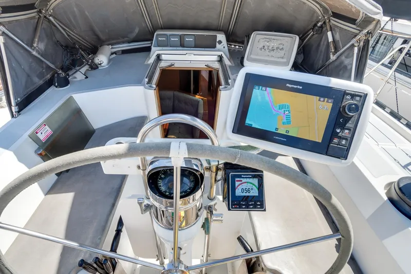 Slide: The Image of Center cockpit of a 1987 Macintosh sailboat with navigation equipment and steering wheel. - 38