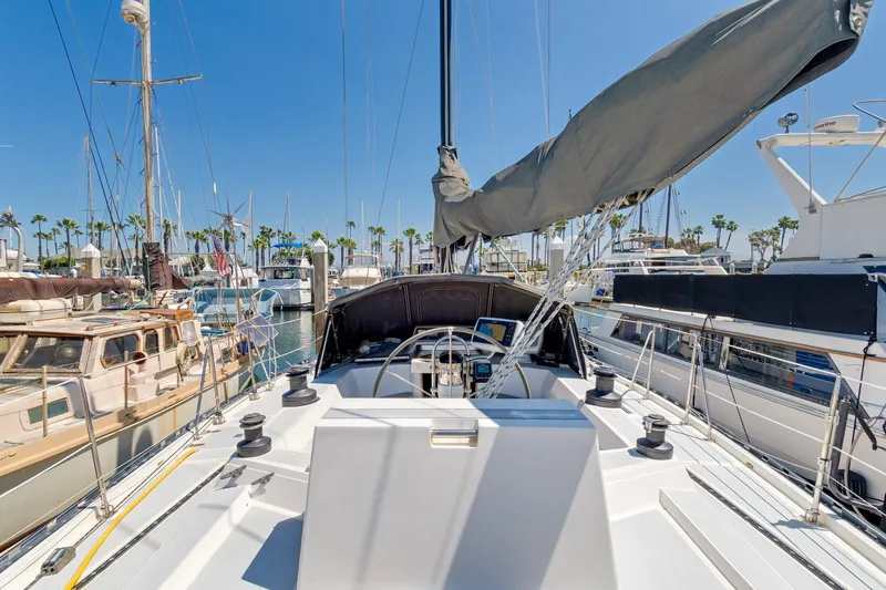 Slide: The Image of 1987 Macintosh Center Cockpit sailboat docked in a sunny marina with palm trees. - 42
