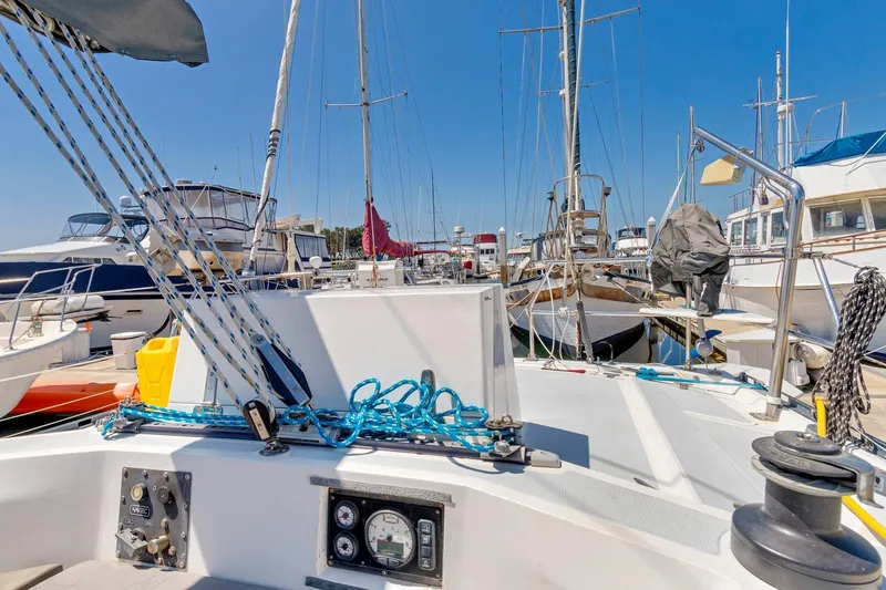 Slide: The Image of 1987 Macintosh Center Cockpit sailboat docked in a marina, surrounded by other boats. - 47