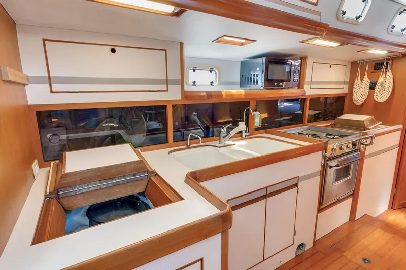 Slide: The Image of 1987 Macintosh Center Cockpit yacht kitchen with stove, sink, and wooden cabinetry. - 7