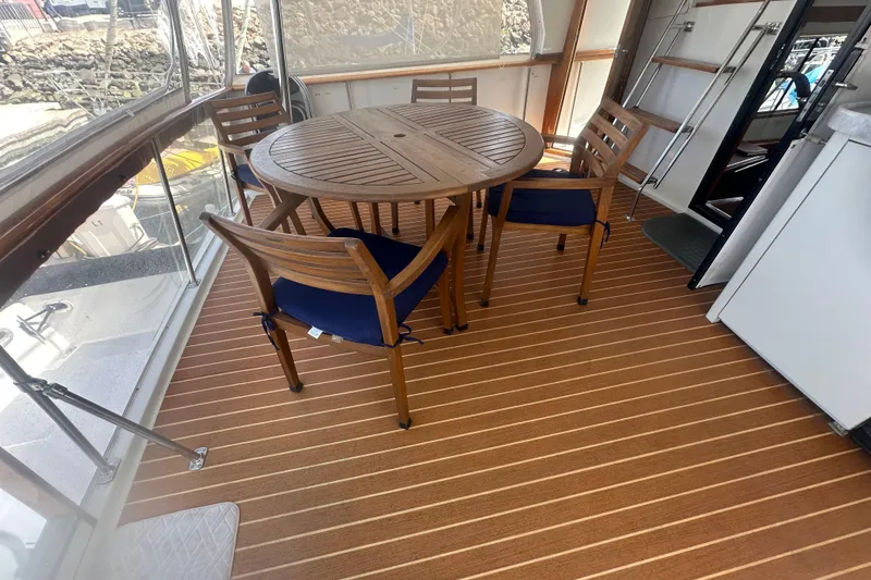 Slide: The Image of 1991 Californian 52 Cockpit Motor Yacht with wooden deck and round table setup. - 15
