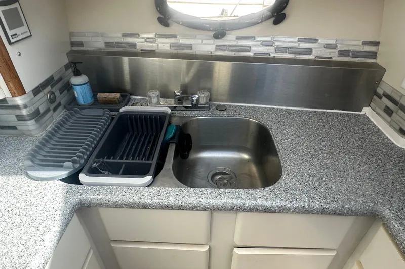 Slide: The Image of Kitchen sink area in a 1991 Californian 52 Cockpit Motor Yacht with modern backsplash. - 4
