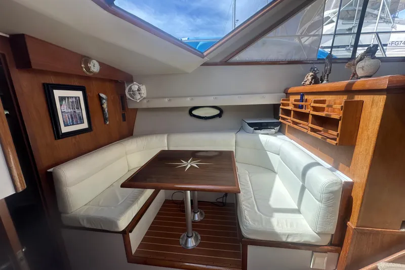 Slide: The Image of Interior of 1991 Californian 52 Cockpit Motor Yacht with white seating and wooden table. - 5