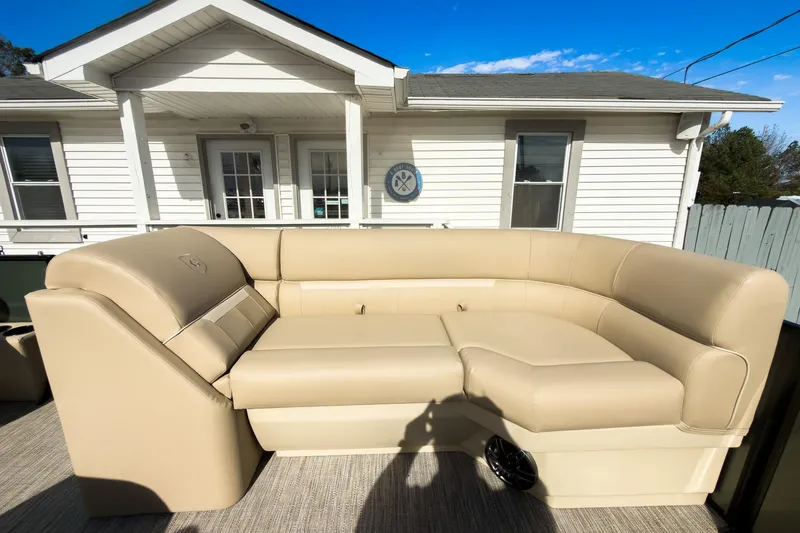 Slide: The Image of 2026 Godfrey Sweetwater Xperience 22' Split Bench Pontoon with beige seating, outdoor setting. - 12