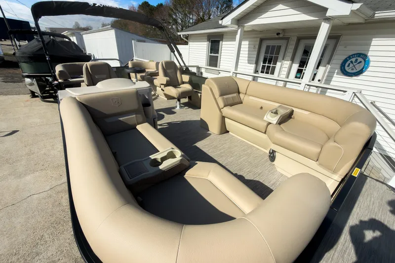 Slide: The Image of 2026 Godfrey Sweetwater Xperience 22' Split Bench Pontoon with beige seating, docked near a white building. - 8