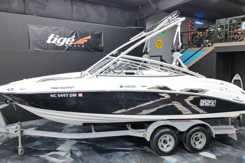 The Image of 2008 Yamaha Boats 212X on trailer, displayed indoors with Tige Boats banner. - 0