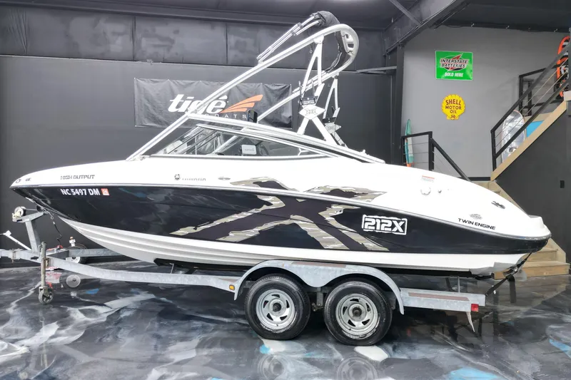 Slide: The Image of 2008 Yamaha Boats 212X on trailer in showroom, featuring sleek black and white design. - 12