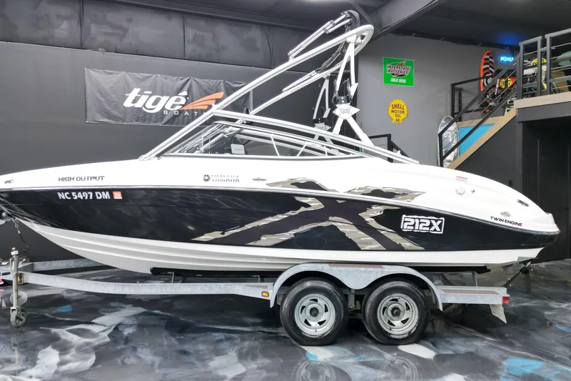 Slide: The Image of 2008 Yamaha Boats 212X on trailer in showroom, featuring sleek design and twin engines. - 13