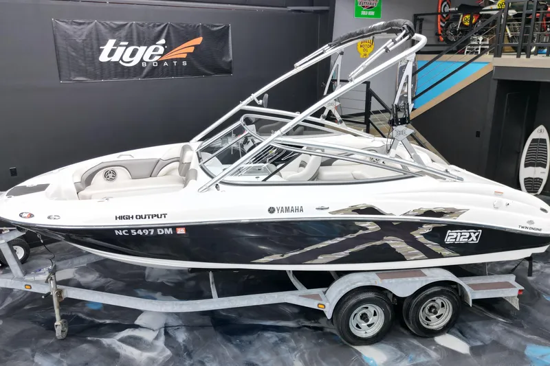 Slide: The Image of 2008 Yamaha Boats 212X on trailer, displayed indoors with Tige Boats banner. - 14
