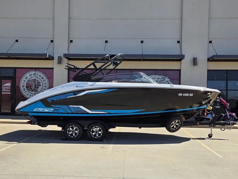The Image of 2021 Yamaha Boats 252XE on trailer in front of building. - 1