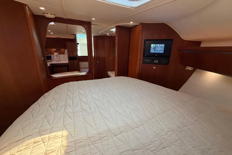Slide: The Image of Luxurious cabin interior of 2005 Tiara Yachts 3600 Sovran with wood finish and cozy bedding. - 29