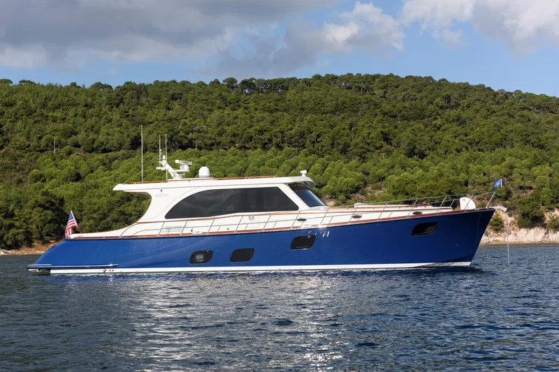 The Image of 2025 Vicem 65 Classic yacht on serene water with lush green forest backdrop. - 1