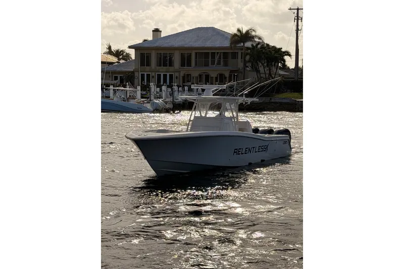 Slide: The Image of 2017 Invincible 39 Open Fisherman boat on water near a waterfront house. - 5