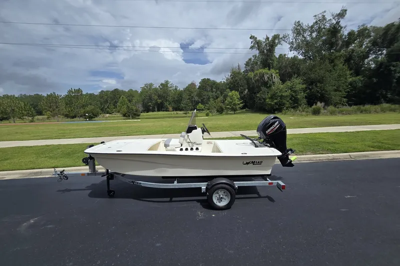 The Image of 2026 Mako Pro Skiff 13 CC boat on trailer, parked on a road with greenery background. - 0