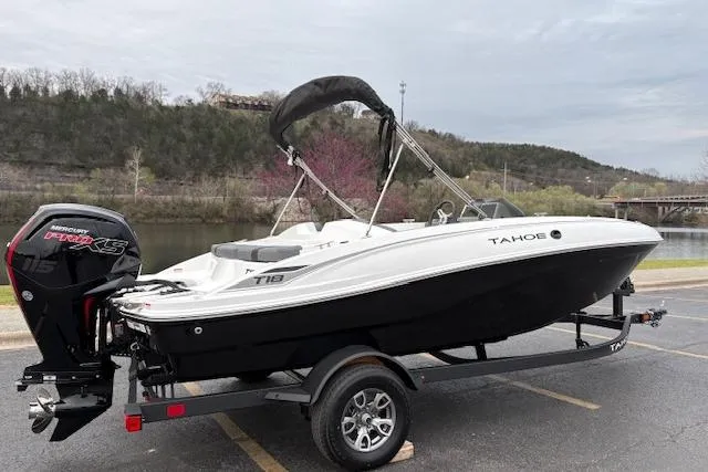 Slide: The Image of 2026 Tahoe T18 boat on trailer, parked near a scenic river backdrop. - 67
