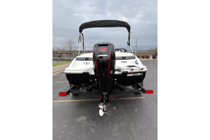 Slide: The Image of 2026 Tahoe T18 boat with Mercury 115 outboard motor, parked on a trailer. - 72