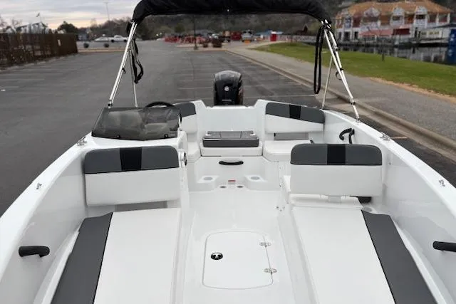 Slide: The Image of 2026 Tahoe T18 boat interior with seating and steering, docked near a waterfront. - 86
