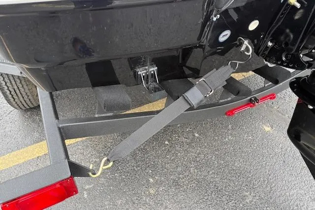 Slide: The Image of 2026 Tahoe T18 boat trailer with secure strap and red reflectors on asphalt. - 99