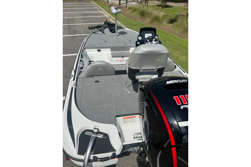 Slide: The Image of 2026 Nitro Z17 boat with Mercury engine, parked on pavement, featuring spacious deck and seating. - 9