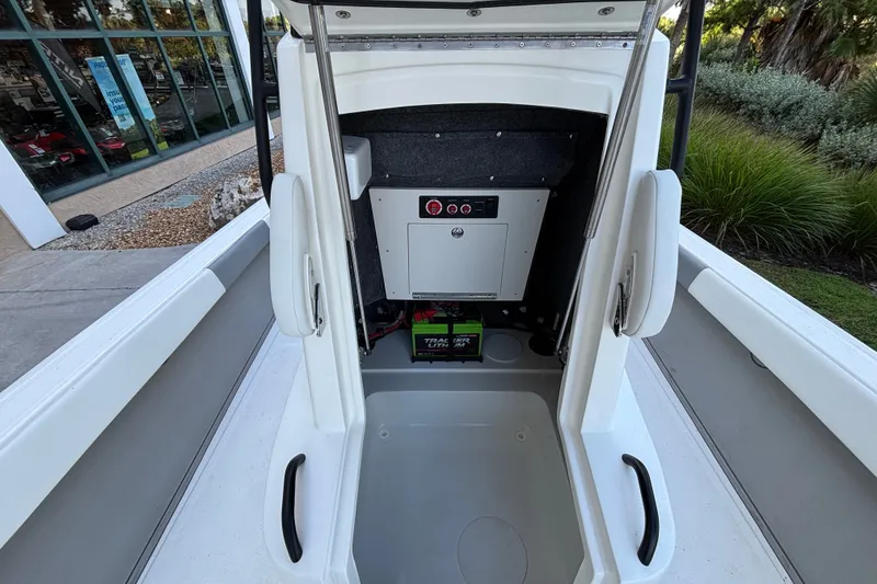 Slide: The Image of Interior view of 2026 Mako 24 APEX boat, showcasing storage and battery compartment. - 13