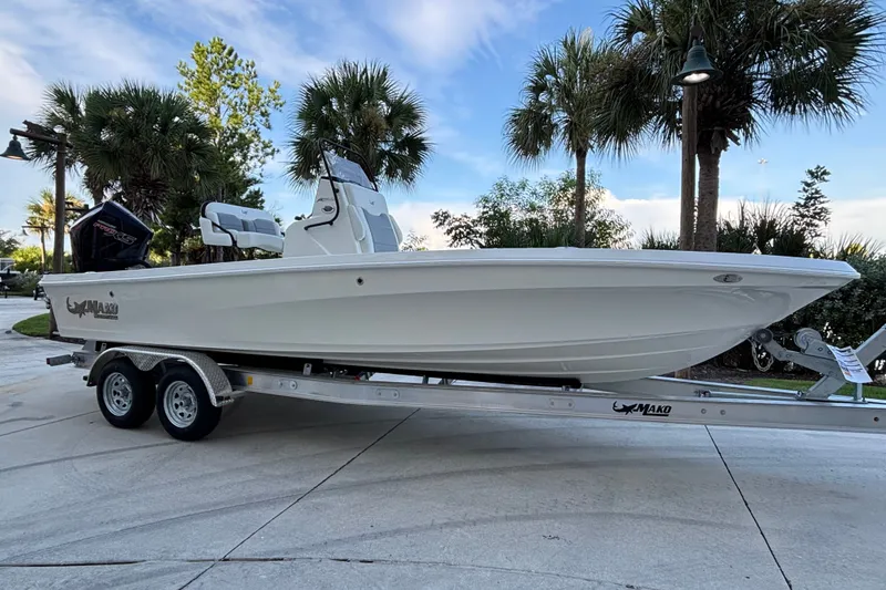 The Image of 2026 Mako 24 APEX boat on trailer, surrounded by palm trees and clear sky. - 0