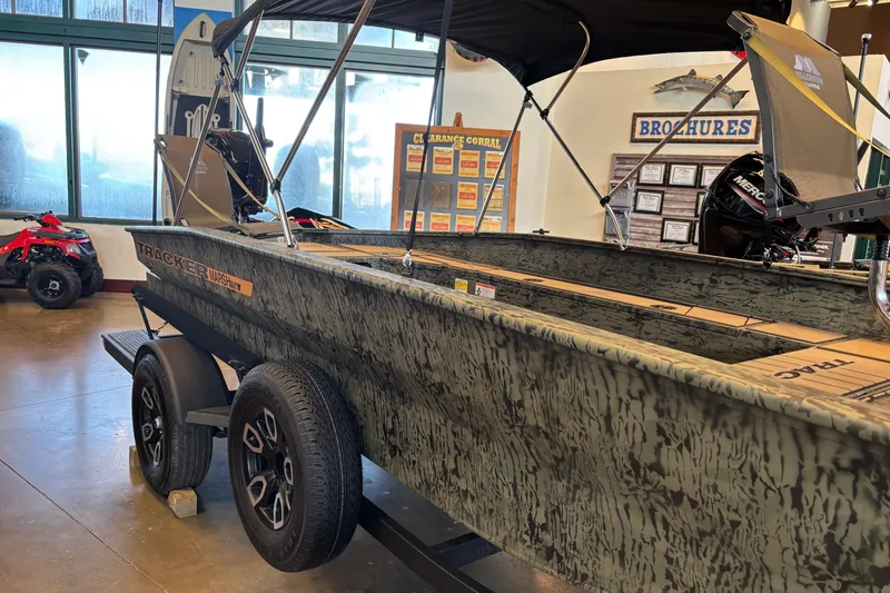 The Image of 2026 Tracker Grizzly 1756 T Marsh boat displayed indoors on a trailer. - 0